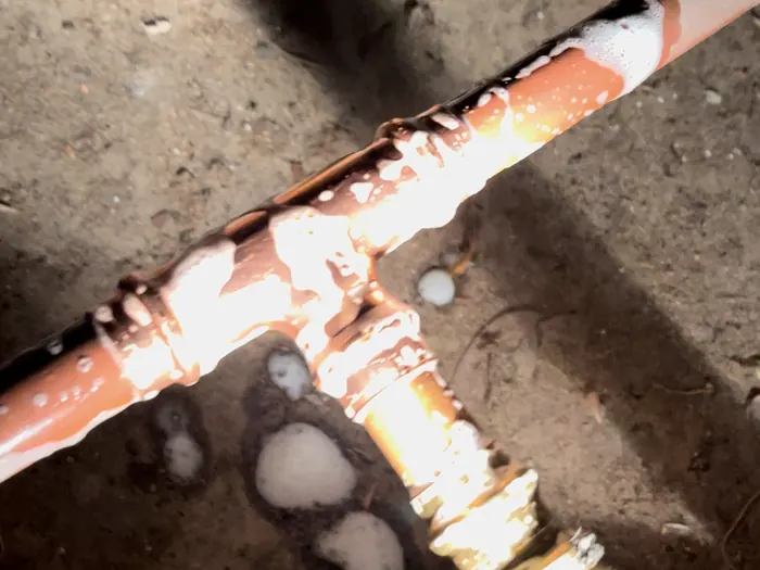 Paul leak-testing a new copper gas tee with soapy water